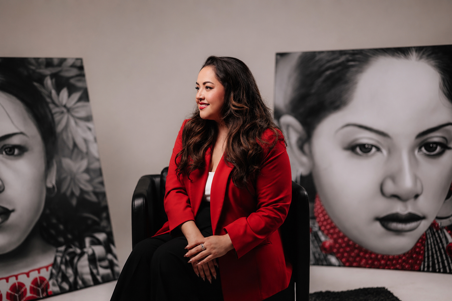 Tania Torres seated in front of large-scale portrait artwork
